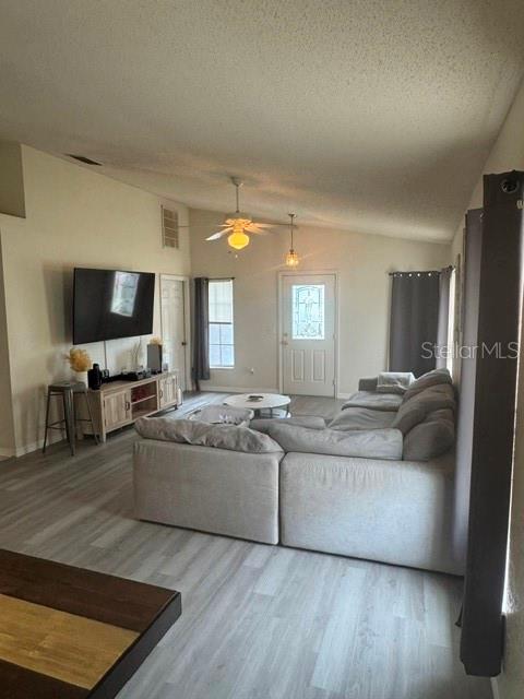 A living room features a large sectional sofa, a television on a console, and light-colored flooring — 8079 GRAND PINES BOULEVARD, LAKELAND, FL