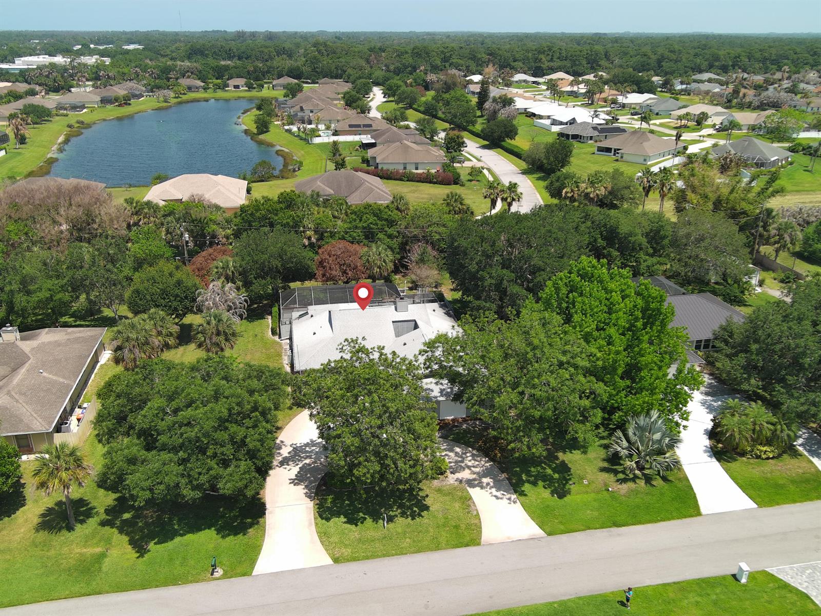 An aerial view shows a single-story house with a screened pool enclosure and circular driveway — 1070 47th Avenue SW, Vero Beach FL 32968, VERO BEACH, FL
