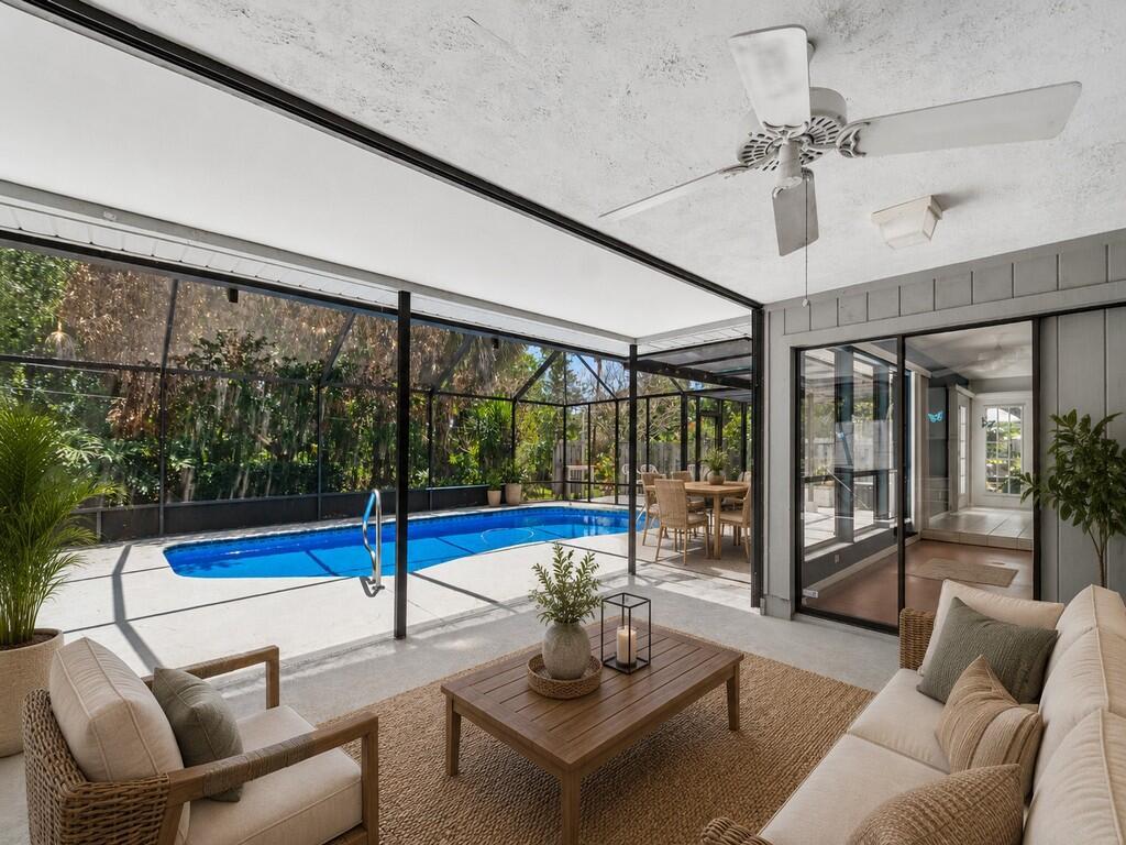 A covered patio features a swimming pool, outdoor seating, and a ceiling fan — 1070 47th Avenue SW, Vero Beach FL 32968, VERO BEACH, FL