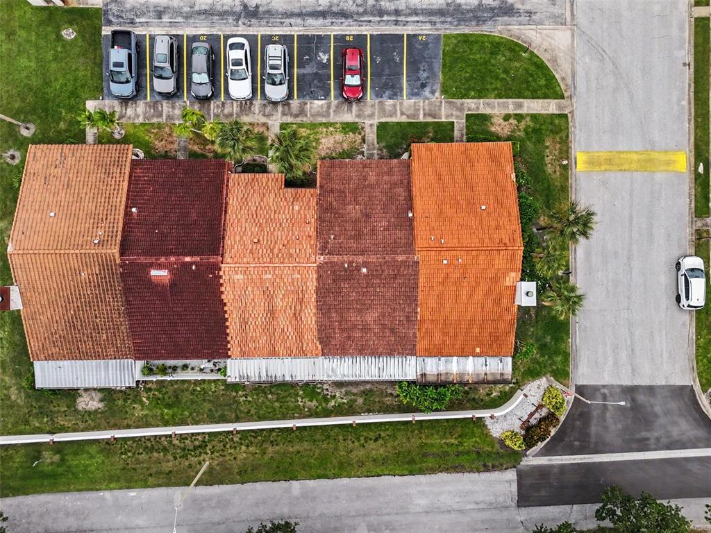 An aerial view shows a multi-unit residential building with a tiled roof and parking spaces — 7360 ULMERTON ROAD UNIT 2B, LARGO, FL