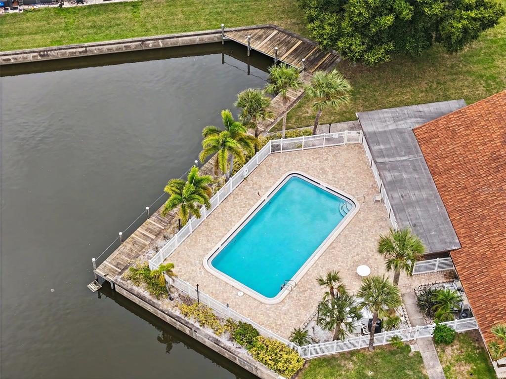 An aerial view of a swimming pool on a patio deck next to a canal — 7360 ULMERTON ROAD UNIT 2B, LARGO, FL