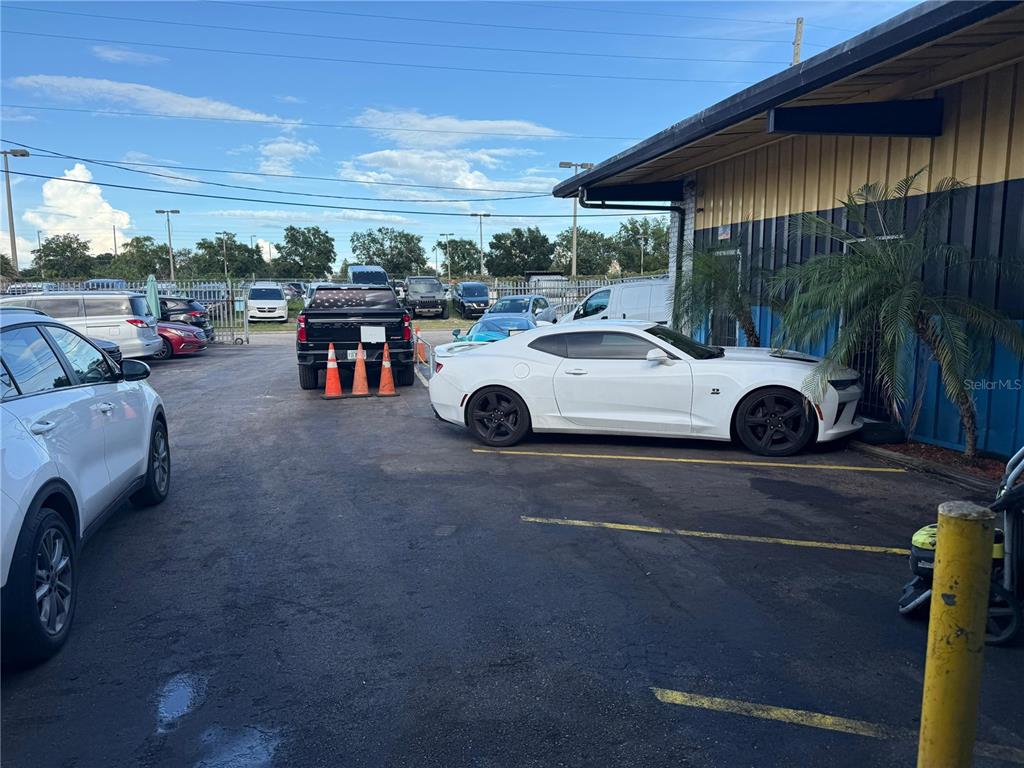 A parking lot with several cars and a white Chevrolet Camaro parked near a building — 578 IRENE STREET, ORLANDO, FL