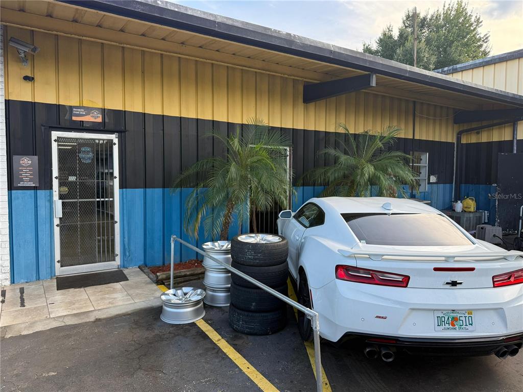 A white Chevrolet Camaro is parked in front of a building with yellow, black, and blue siding — 578 IRENE STREET, ORLANDO, FL