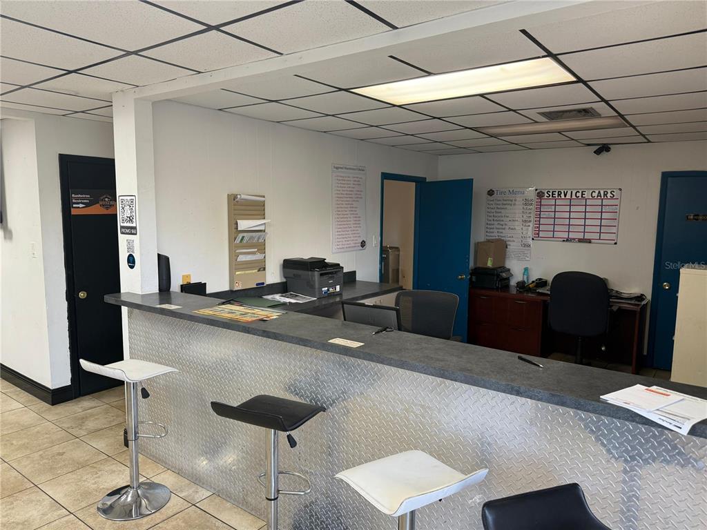 A commercial service counter features a diamond-plate front, bar stools, and a drop ceiling — 578 IRENE STREET, ORLANDO, FL