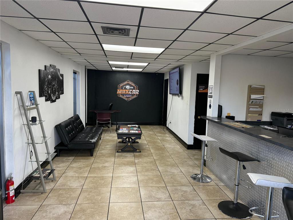 A commercial office space features a waiting area with a black sofa, coffee table, and reception counter — 578 IRENE STREET, ORLANDO, FL