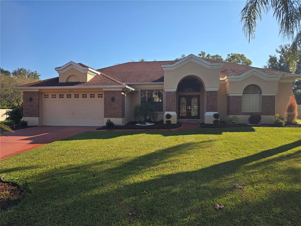 A single-story house with a brick and stucco facade, a two-car garage, and a lawn — 1030 ROWLAND PICKERT LANE, LUTZ, FL