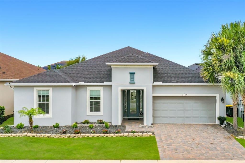 A single-story house with a gray exterior, dark shingled roof, and a paved driveway — 3447 CURRENT, WINTER GARDEN, FL