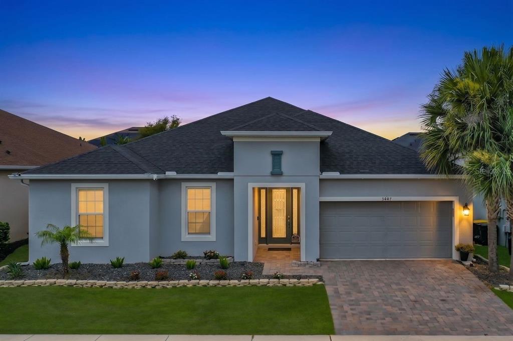A single-story gray house with a paver driveway, a two-car garage, and a landscaped yard — 3447 CURRENT, WINTER GARDEN, FL