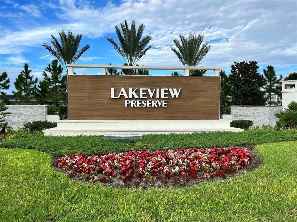 A wooden sign for Lakeview Preserve stands behind a flower bed and green lawn — 3447 CURRENT, WINTER GARDEN, FL