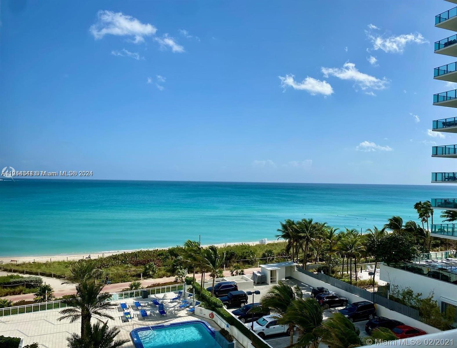 An elevated view of a swimming pool, parking lot, and beach along the ocean — 6917 Collins Ave # 809, Miami Beach FL 33141, MIAMI BEACH, FL