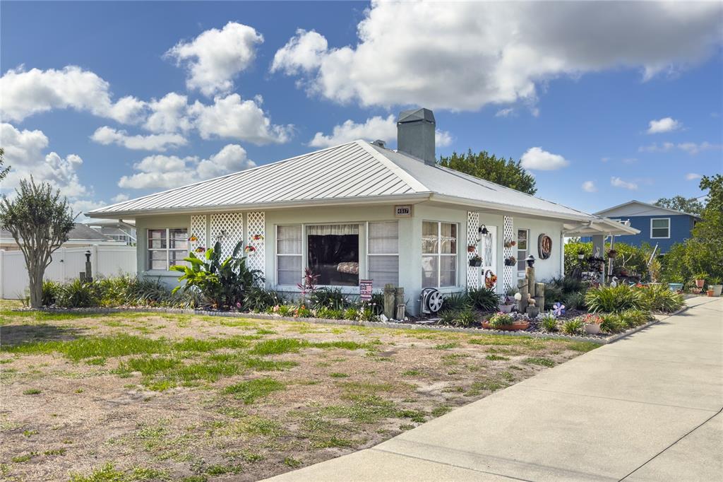 A single-story house with a metal roof, light-colored siding, and a concrete driveway — 4517 8TH STREET COURT E, ELLENTON, FL