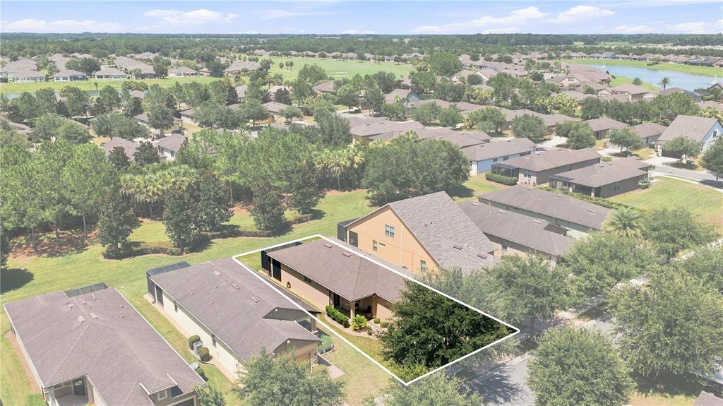 An aerial view shows a single-story house with a brown roof and a fenced backyard — 7684 SW 94TH CIRCLE, OCALA, FL