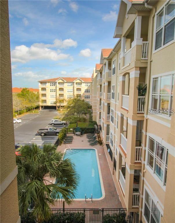 An elevated view of an apartment complex courtyard featuring a swimming pool and parking lot — 1216 S MISSOURI AVENUE UNIT 428, CLEARWATER, FL