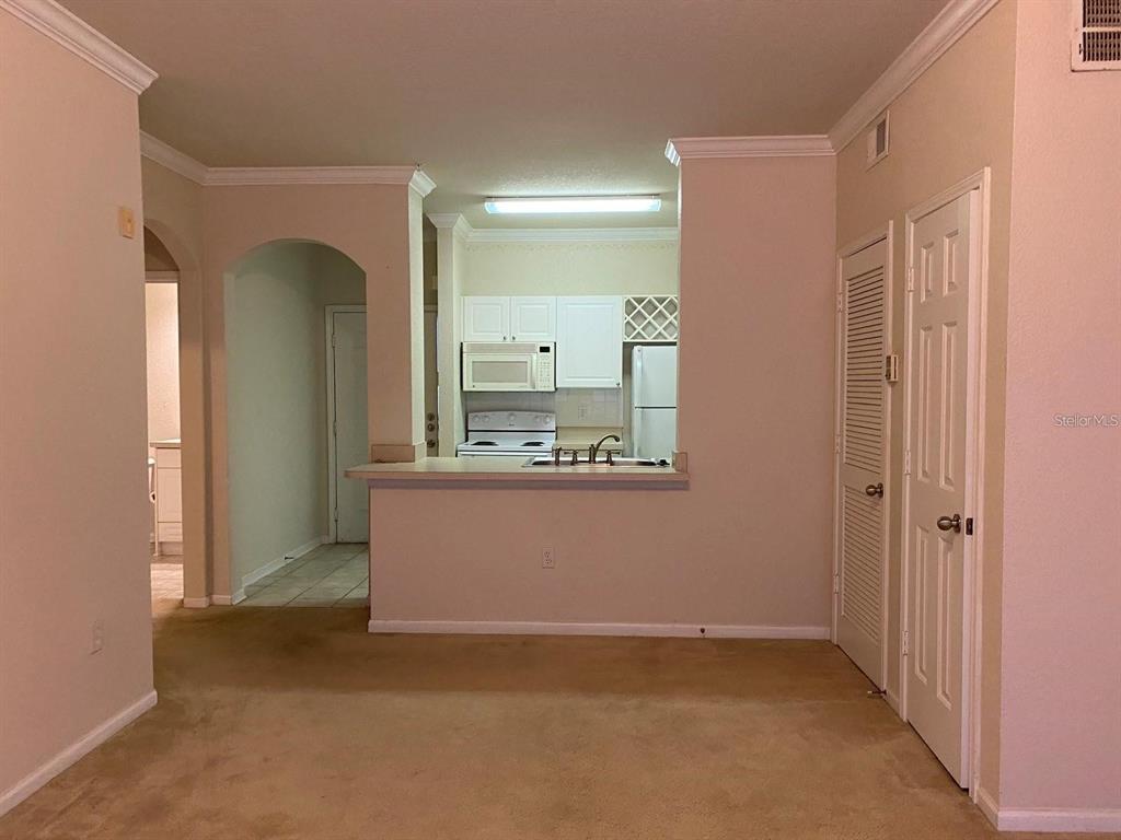 A kitchen features white cabinets, a white refrigerator, a microwave, and a double-basin sink — 1216 S MISSOURI AVENUE UNIT 428, CLEARWATER, FL