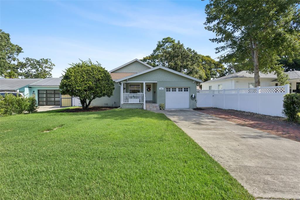 A single-story house with green siding, a front porch, and a concrete driveway — 309 NIBLICK WAY, ORLANDO, FL