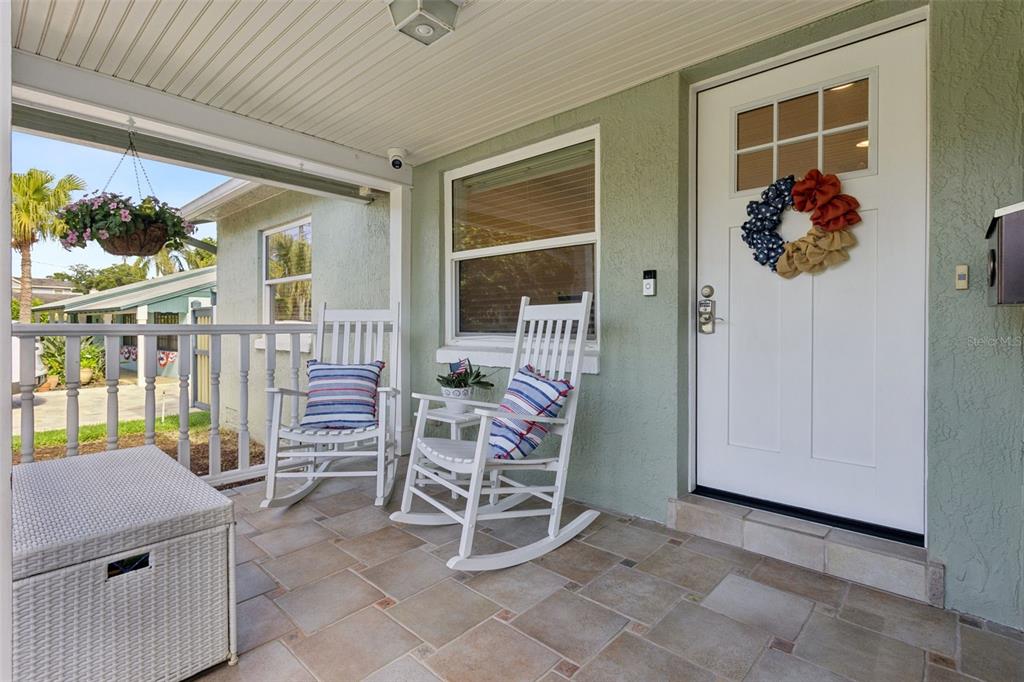 A covered front porch features two white rocking chairs, a tiled floor, and a white door — 309 NIBLICK WAY, ORLANDO, FL