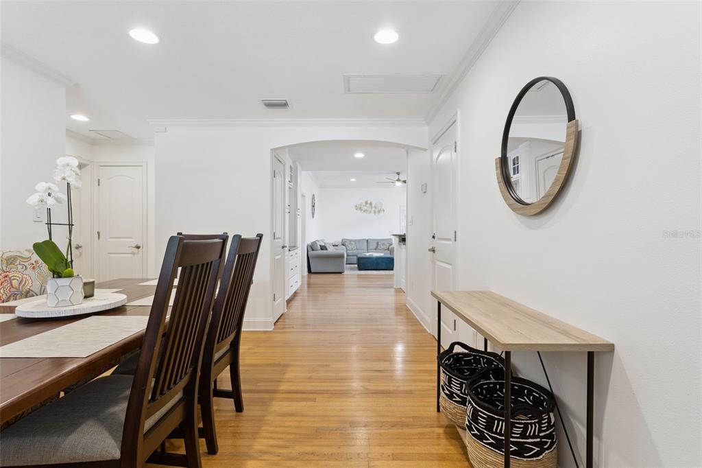 A dining area with a wooden table leads through an arched doorway to a living room — 309 NIBLICK WAY, ORLANDO, FL