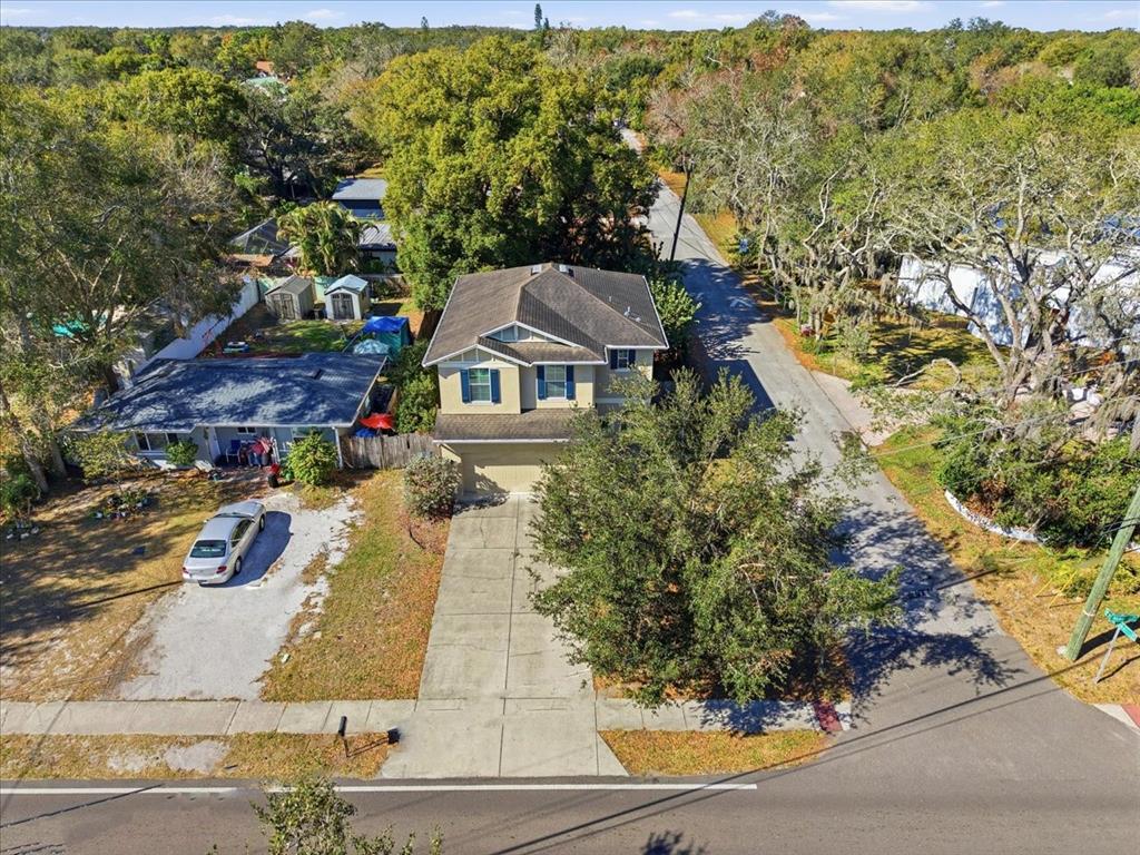 An aerial view shows a two-story house with a concrete driveway and surrounding trees — 12330 N ROME AVENUE, TAMPA, FL