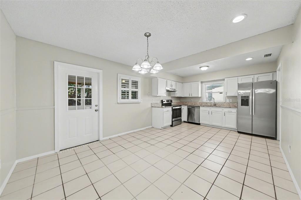 A kitchen with white cabinets, stainless steel appliances, and light-colored tile flooring — 722 GALSWORTHY AVENUE, ORLANDO, FL