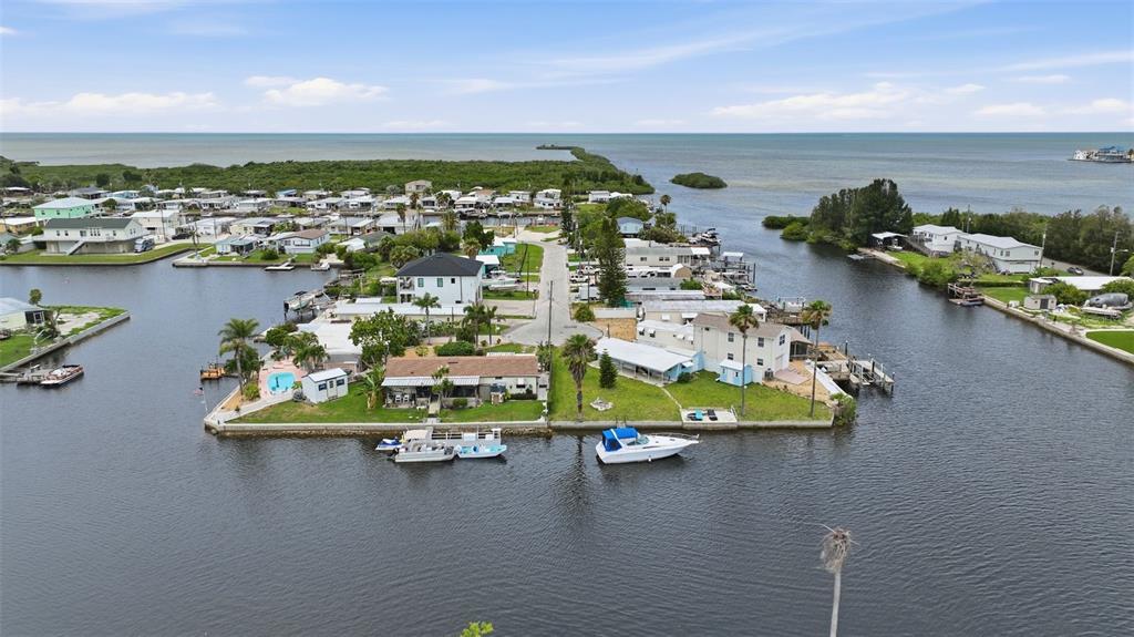 An aerial view shows waterfront homes with private docks and boats along a canal — 13039 PORT COURT, HUDSON, FL
