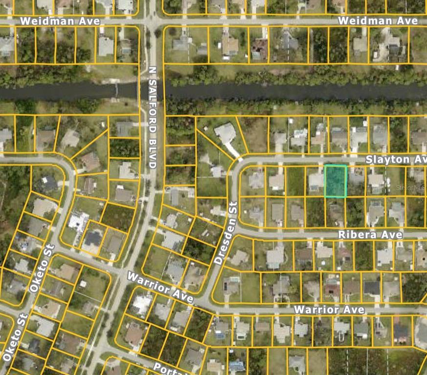 This is an aerial map showing a highlighted residential lot in a suburban neighborhood — SLAYTON AVENUE, NORTH PORT, FL