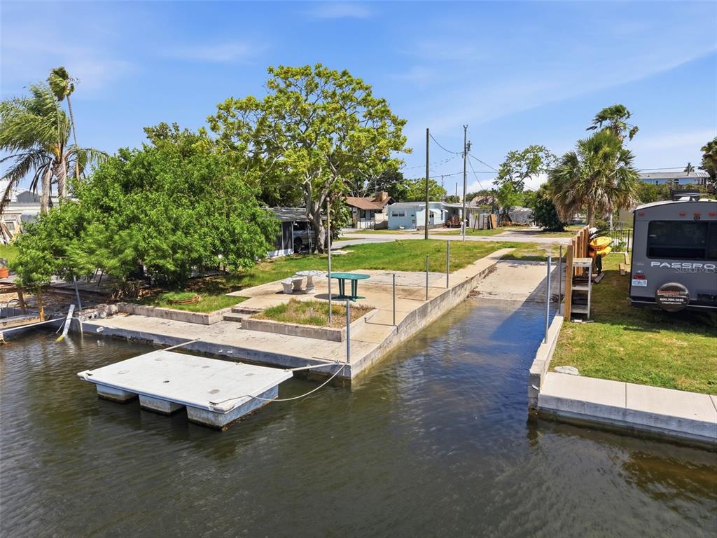 An elevated view of a concrete boat ramp and dock area next to a canal — 6737 OSPREY LANE, HUDSON, FL