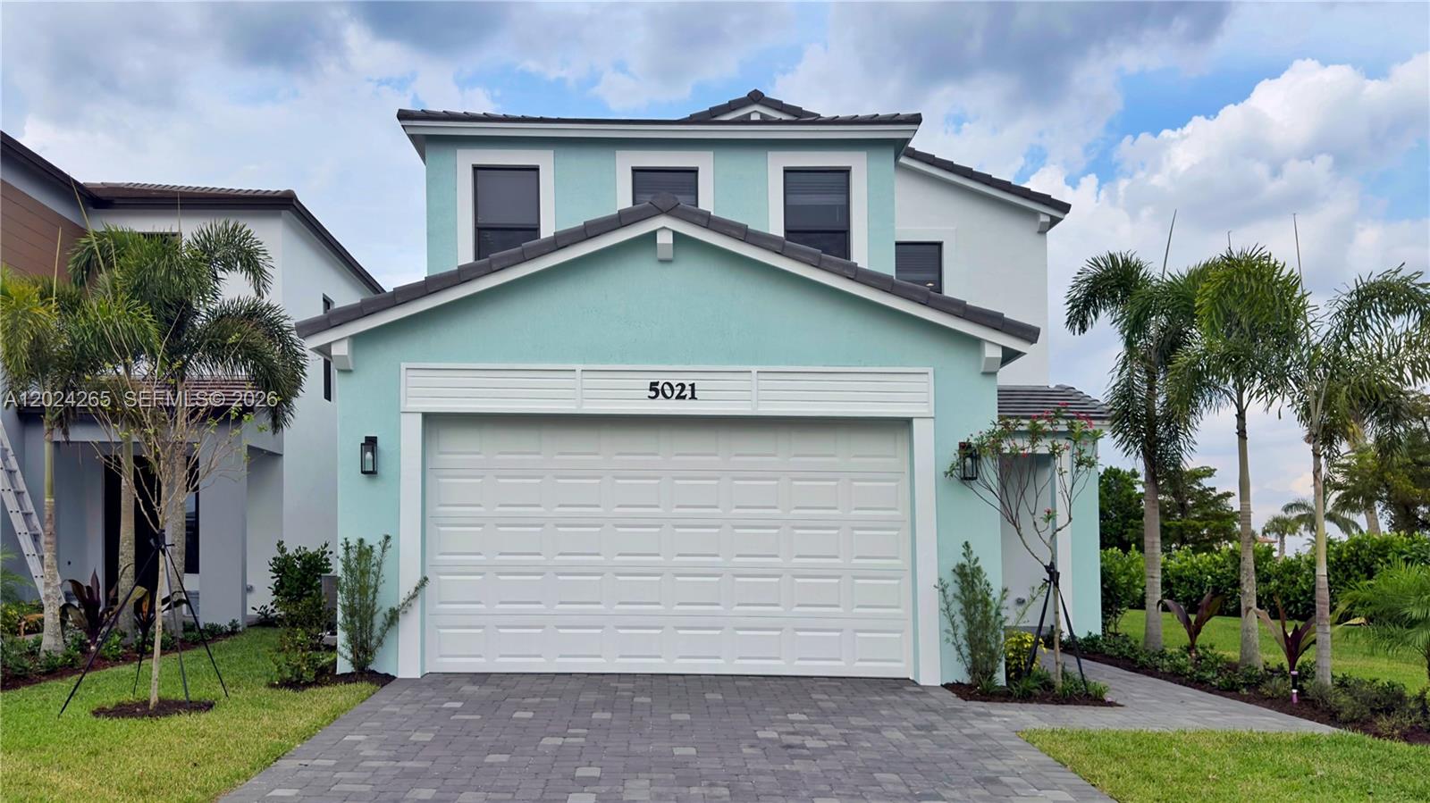 A two-story house with a light blue exterior, a white garage door, and palm trees — 5021 Coquina Pl # 5021, Westlake FL 33470, WESTLAKE, FL