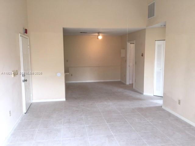 An interior view of a room with light-colored tile flooring and white walls — 18324 NW 68 # H, Hialeah FL 33015, HIALEAH, FL