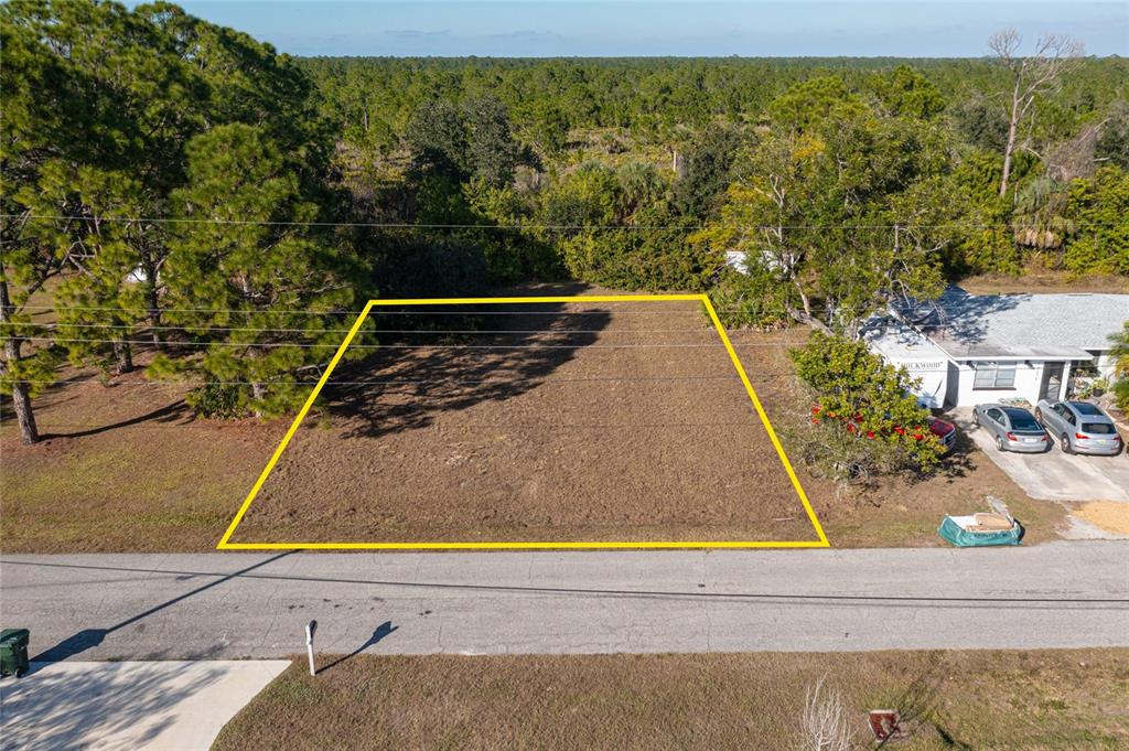 An aerial view shows a cleared, rectangular vacant lot outlined in yellow along a road — LOTS 17 & 18 HERNANDO ROAD, NORTH PORT, FL