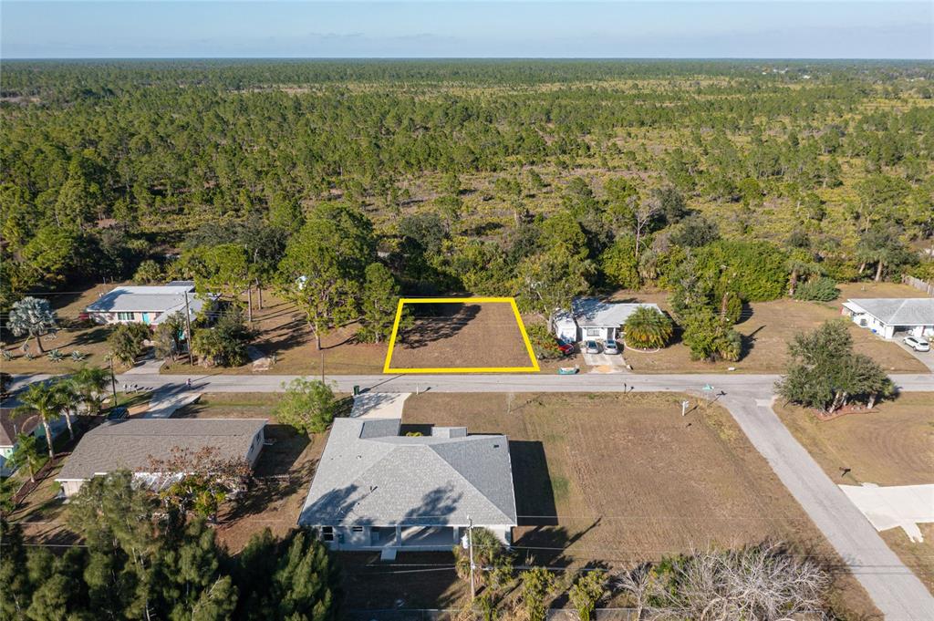 An aerial view shows a vacant, rectangular residential lot outlined in yellow along a street — LOTS 17 & 18 HERNANDO ROAD, NORTH PORT, FL