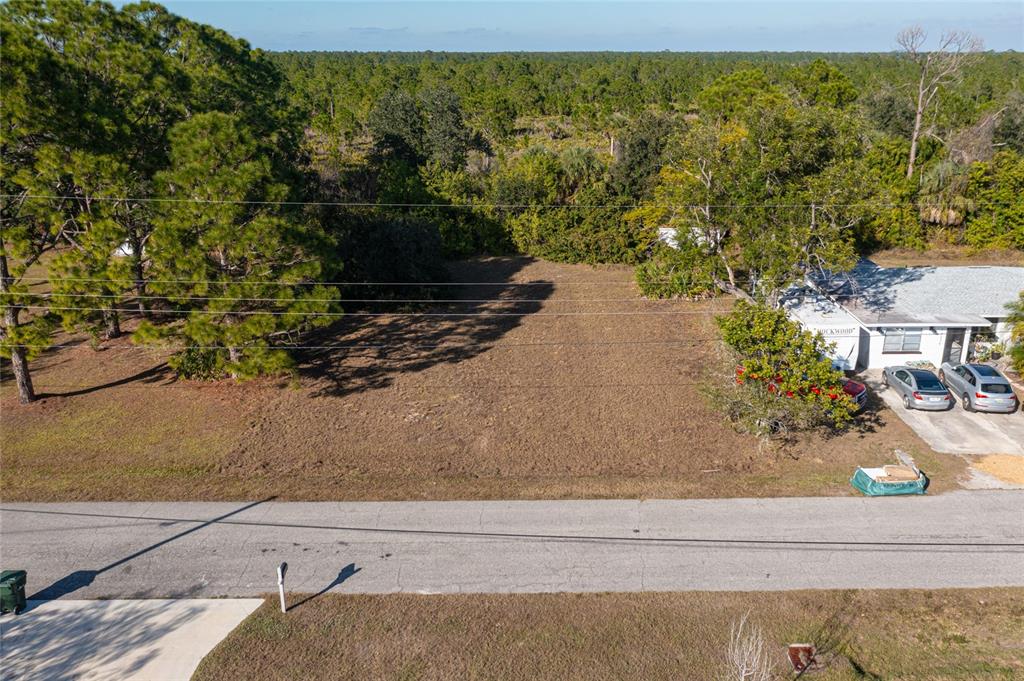 An elevated view shows a vacant, cleared residential lot situated between two existing properties — LOTS 17 & 18 HERNANDO ROAD, NORTH PORT, FL