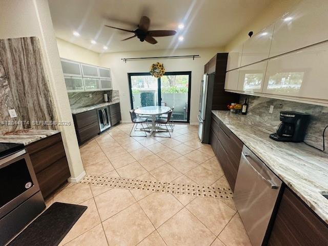 A modern kitchen features dark wood cabinetry, marble-patterned countertops, and a dining area with sliding doors — 4318 NW 113th Pl, Doral FL 33178, DORAL, FL