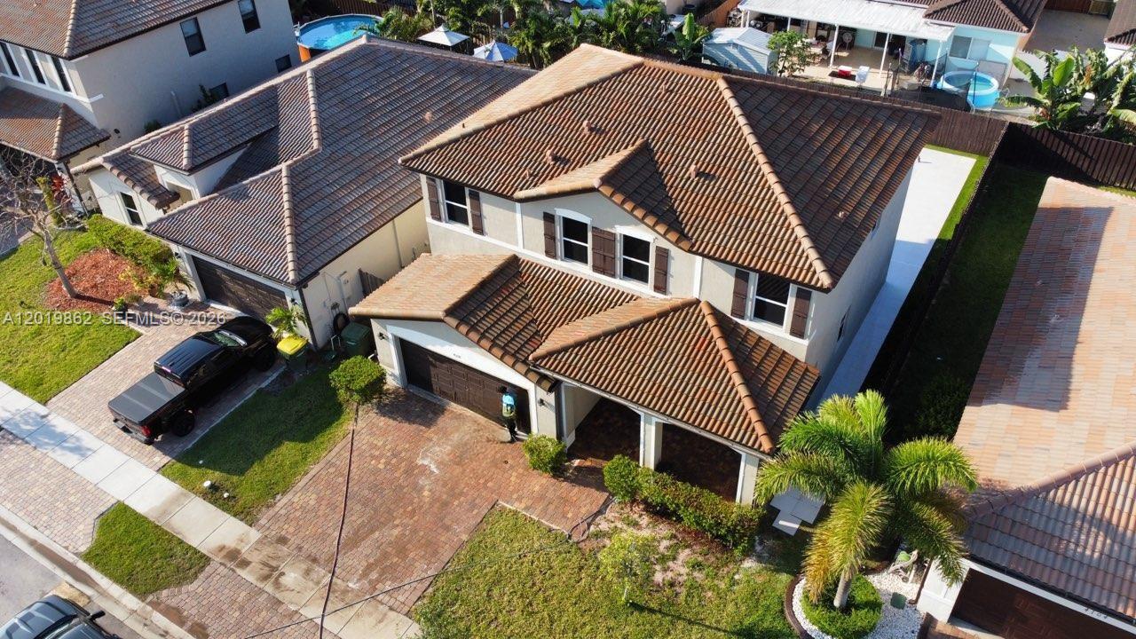 An aerial view of a two-story suburban house with a tiled roof and driveway — HOMESTEAD, FL