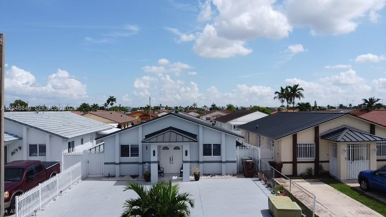 An exterior view of a single-story house with a gray facade and paved driveway — 2727 W 70th St, Hialeah FL 33016, HIALEAH, FL