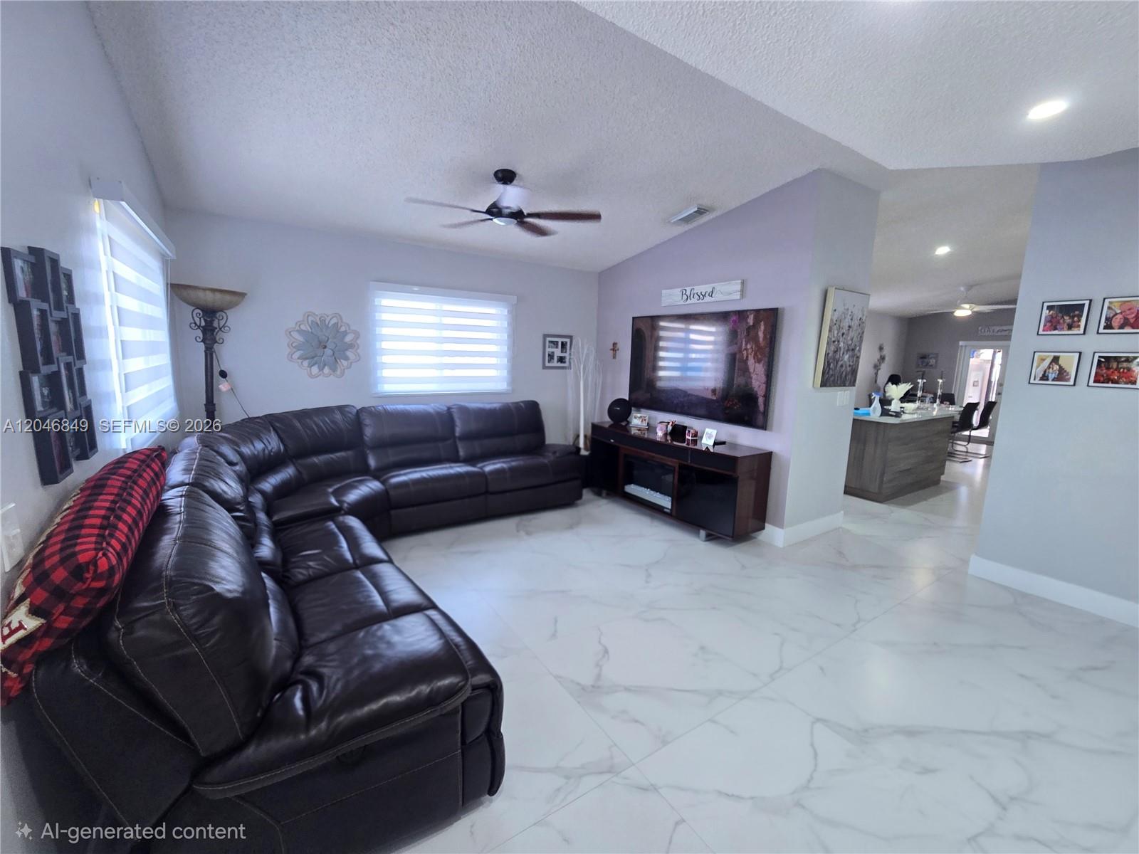 A living room features a large dark leather sectional, white marble flooring, and a television — 2727 W 70th St, Hialeah FL 33016, HIALEAH, FL