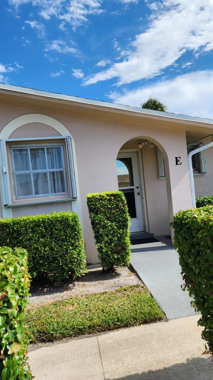 The exterior of a light-colored building features a front entrance marked with the letter E — 2784 DUDLEY DRIVE E UNIT E, WEST PALM BEACH, FL