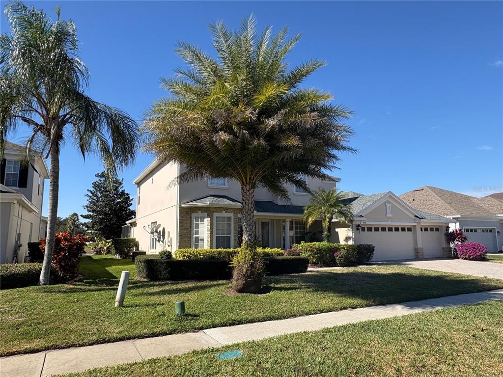 A two-story house with a palm tree in the front yard and a garage — 9718 PINEOLA DRIVE, ORLANDO, FL
