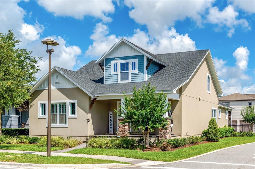 A two-story house with tan stucco, blue siding, a front porch, and a dormer window — 13347 GABOR AVENUE, ORLANDO, FL