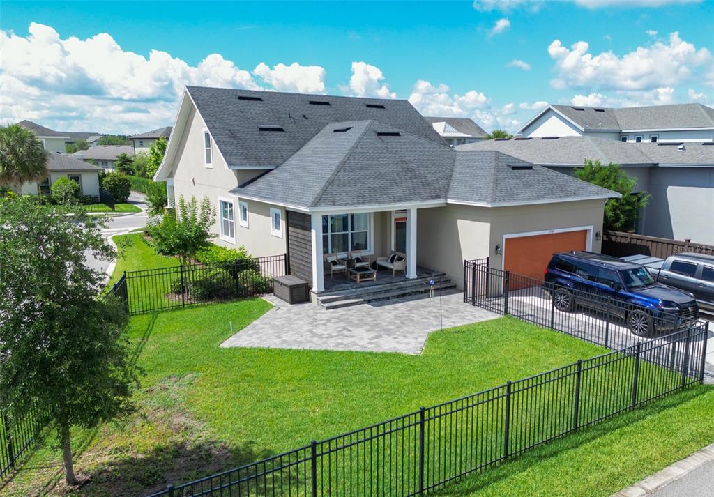 An aerial view of a suburban house with a paved patio, fenced yard, and garage — 13347 GABOR AVENUE, ORLANDO, FL