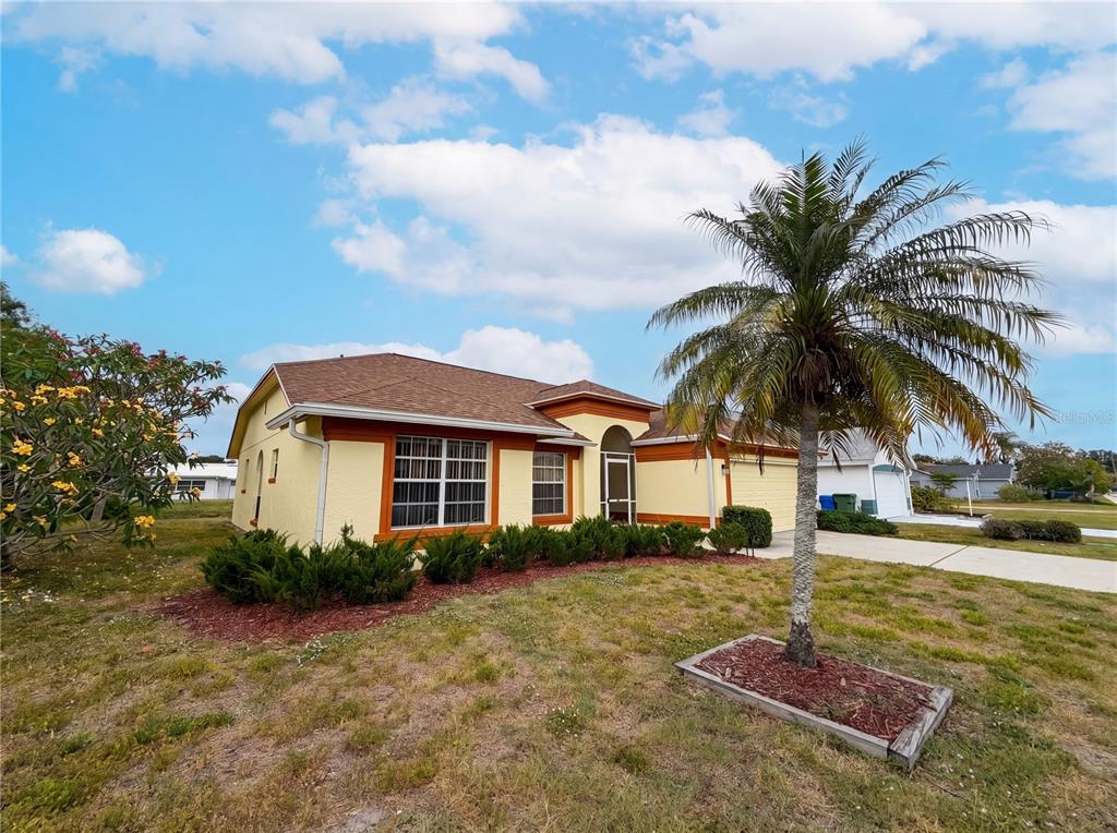A yellow single-story house with a brown roof and a palm tree in the yard — 712 45TH STREET E, BRADENTON, FL