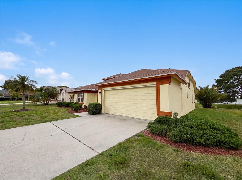 A yellow house with an attached two-car garage and a concrete driveway — 712 45TH STREET E, BRADENTON, FL