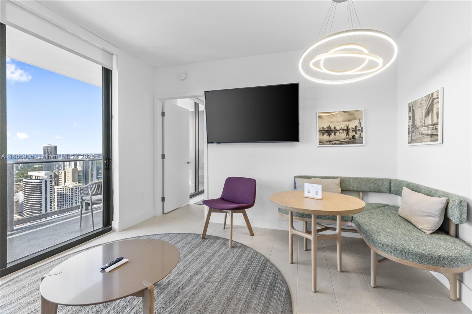 A modern living area features a corner banquette, a purple chair, and a city view — 601 NE 1st Ave # 4607, Miami FL 33132, MIAMI, FL