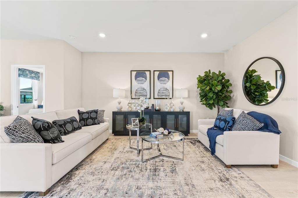 A living room features two white sofas, a dark console table, and a circular mirror — 12775 SEAGRASS DRIVE, PUNTA GORDA, FL