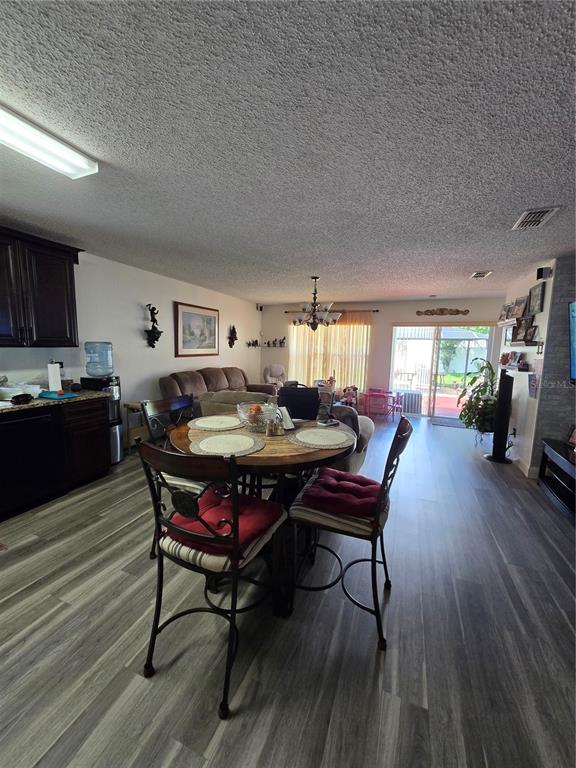 A dining area with a round table sits between a kitchen and a living room — 3277 AMBERLEY PARK CIRCLE, KISSIMMEE, FL