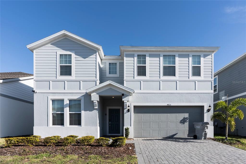 A two-story light gray house with a two-car garage and a paved driveway — 4425 KAIPO ROAD, DAVENPORT, FL