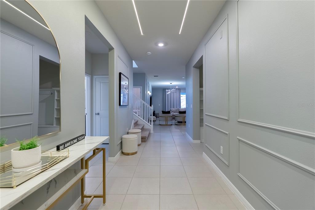 A hallway features light gray walls with molding, tile flooring, and a modern console table — 4425 KAIPO ROAD, DAVENPORT, FL