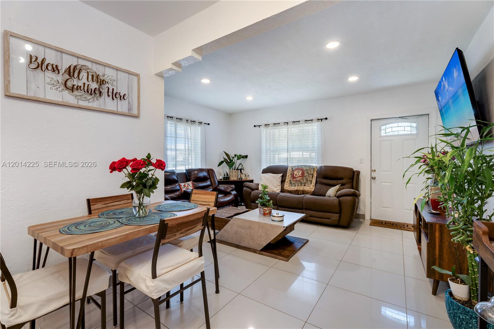 A living and dining area features white tile floors, brown leather furniture, and a wall sign — 1059 NW 77th St, Miami FL 33150, MIAMI, FL