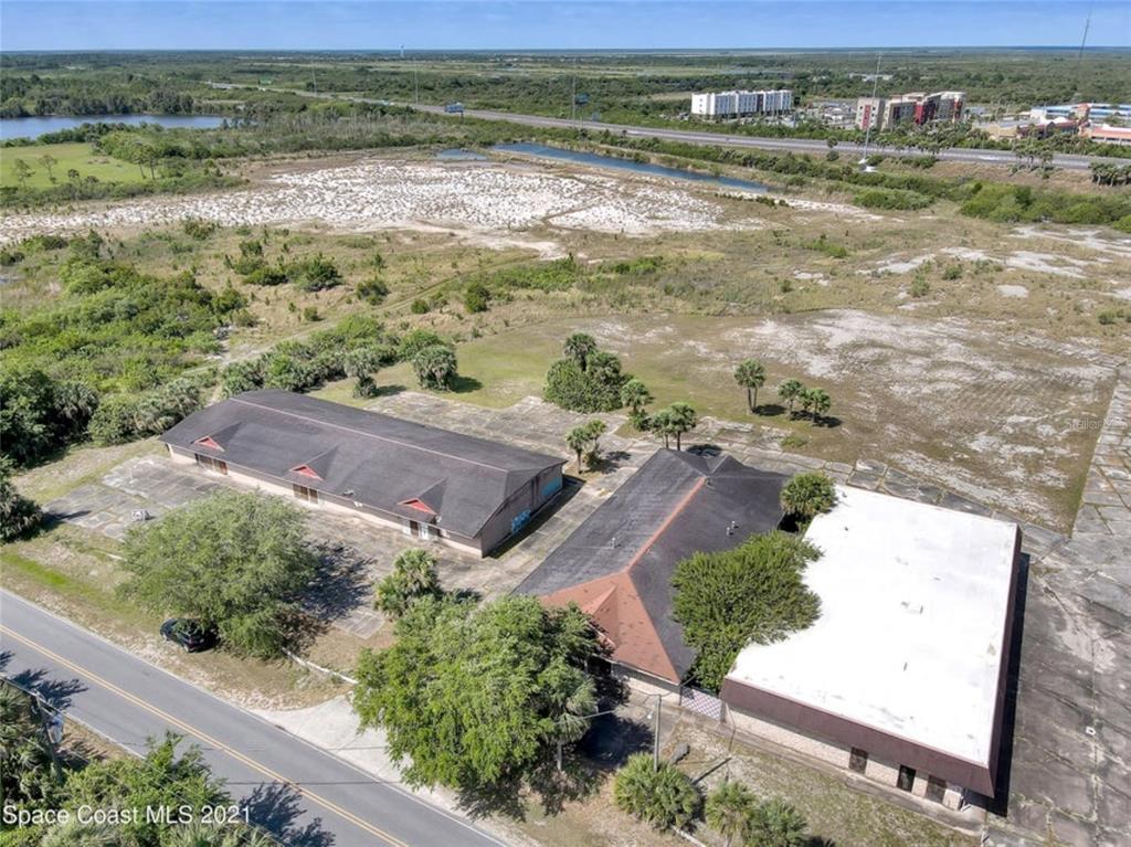 An aerial view shows two commercial buildings situated on a large, partially paved lot — 8251 WINDOVER WAY, TITUSVILLE, FL