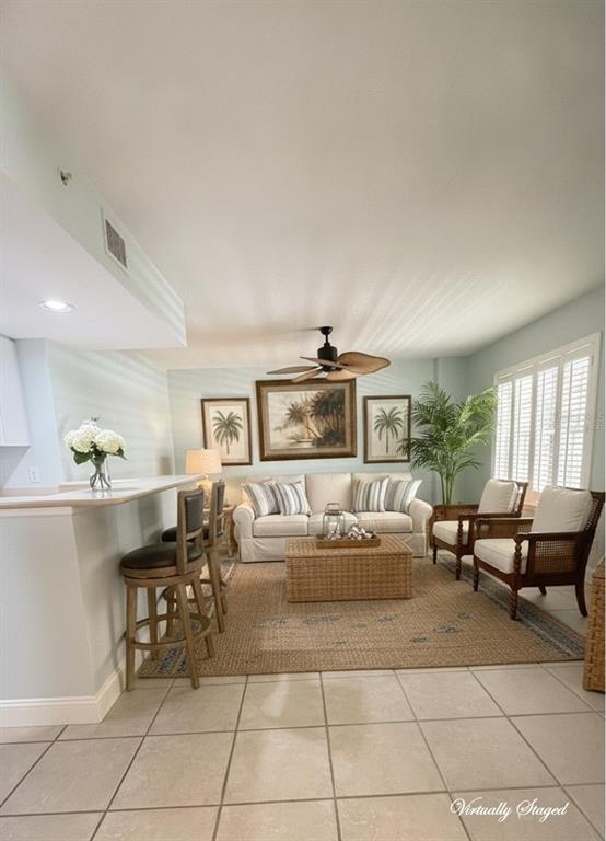 A living room with a sofa, two armchairs, a breakfast bar, and tile flooring — 4670 LINKS VILLAGE DRIVE UNIT B301, PONCE INLET, FL