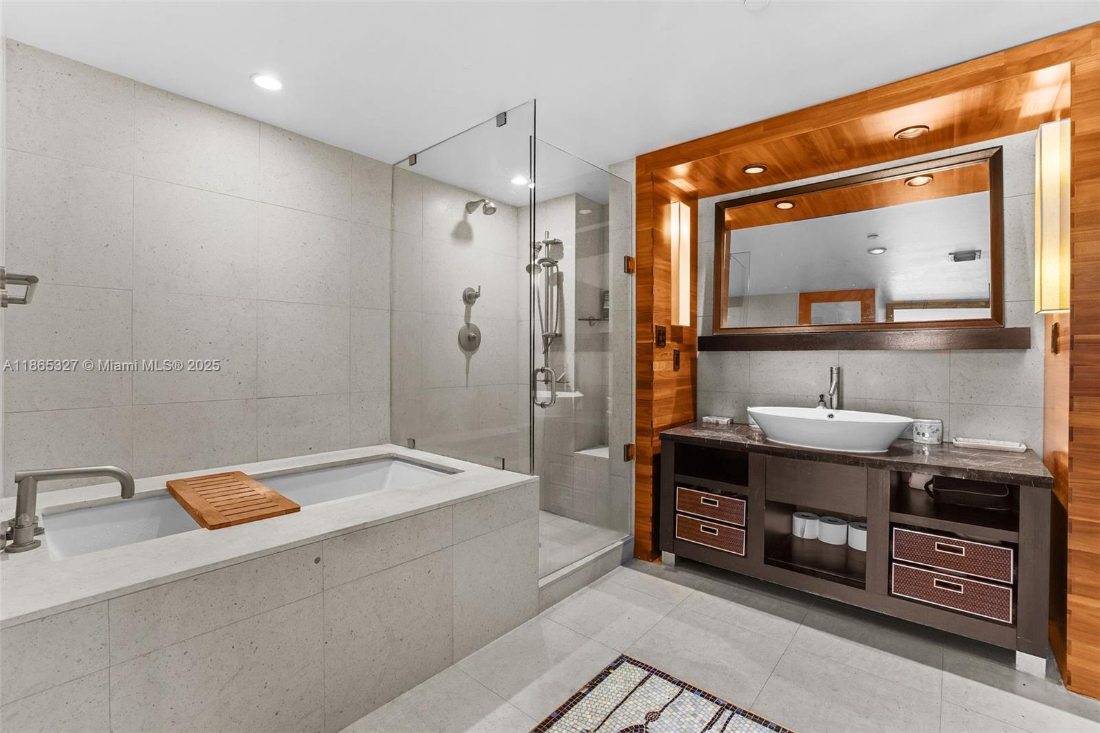 A modern bathroom features a stone-tiled soaking tub, a glass shower, and a wooden vanity — 6801 Collins Ave # 815, Miami Beach FL 33141, MIAMI BEACH, FL